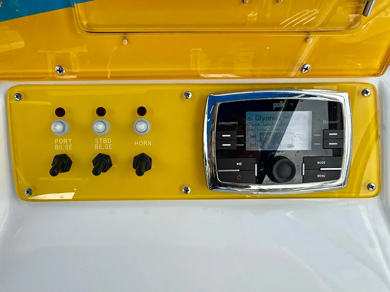Slide: The Image of Control panel of a 2015 Concept 27' CC boat with switches and a Polk audio system. - 19