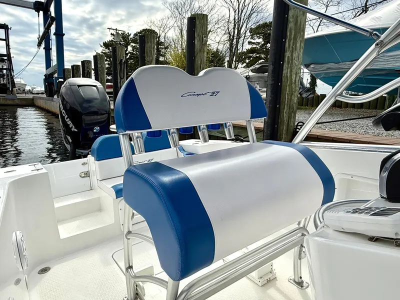 Slide: The Image of 2015 Concept 27' CC boat with blue and white seating, docked near water. - 21