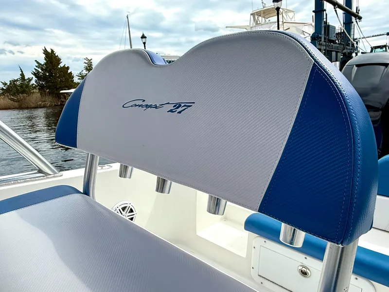 Slide: The Image of 2015 Concept 27' CC boat seat with blue and white upholstery, docked by the water. - 22