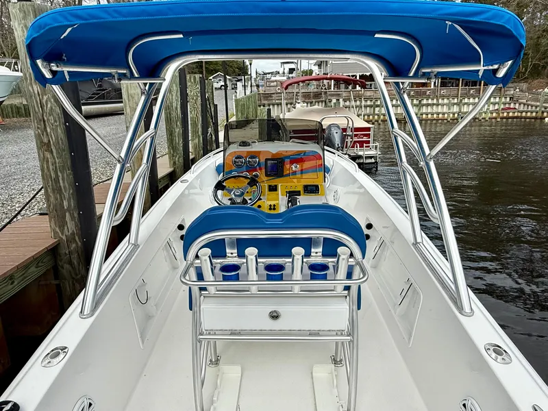 Slide: The Image of 2015 Concept 27' CC boat with blue canopy and sleek interior design at a dock. - 23