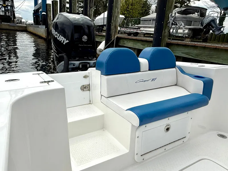 Slide: The Image of 2015 Concept 27' CC boat with blue and white seating, docked with Mercury outboard engine. - 24