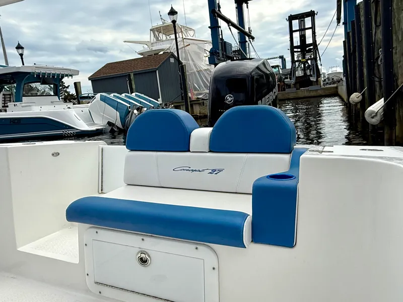 Slide: The Image of 2015 Concept 27' CC boat with blue and white seating at a marina. - 26