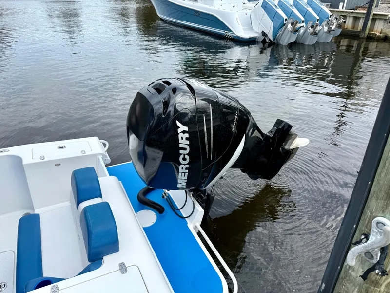 Slide: The Image of 2015 Concept 27' CC boat with Mercury outboard motor, docked on calm water. - 27