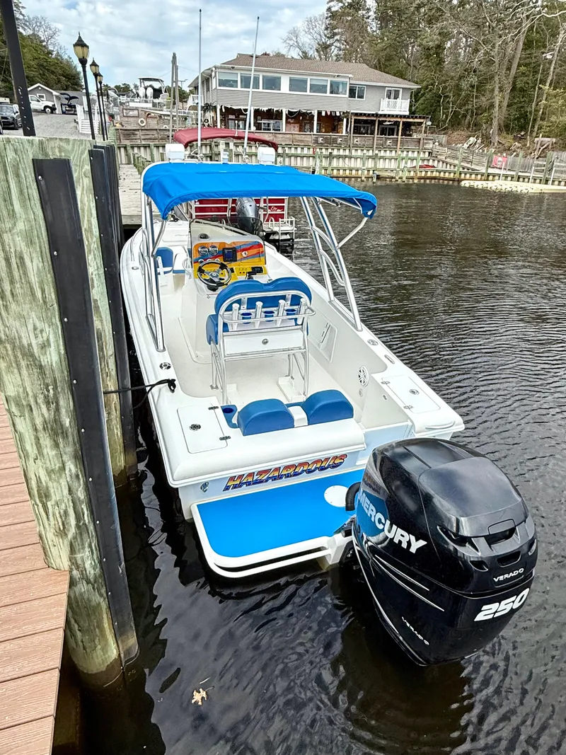 Slide: The Image of 2015 Concept 27' CC boat docked, featuring blue seating and a Mercury 250 engine. - 28