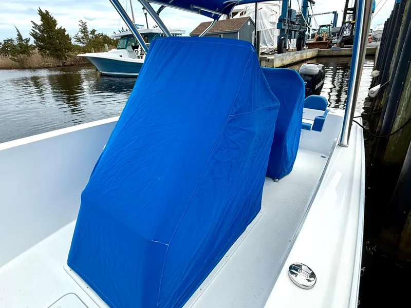 Slide: The Image of 2015 Concept 27' CC boat with blue seat covers docked by the water. - 29