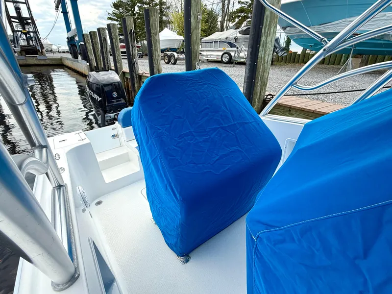 Slide: The Image of Blue-covered seats on a 2015 Concept 27' CC boat docked by the water. - 30