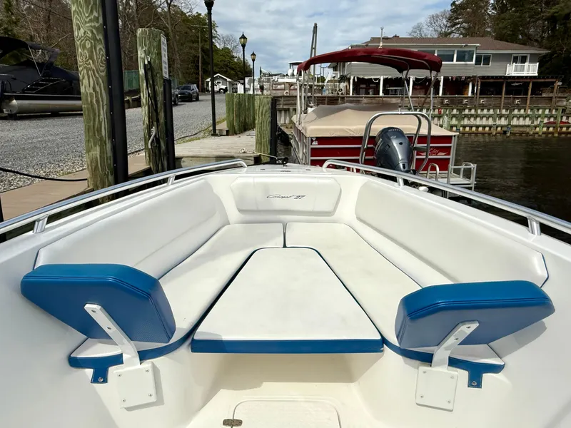 Slide: The Image of 2015 Concept 27' CC boat with white and blue seating at a dock. - 8