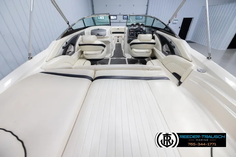 Slide: The Image of 2007 Monterey 234 FS boat interior with white seating and dashboard in showroom. - 13