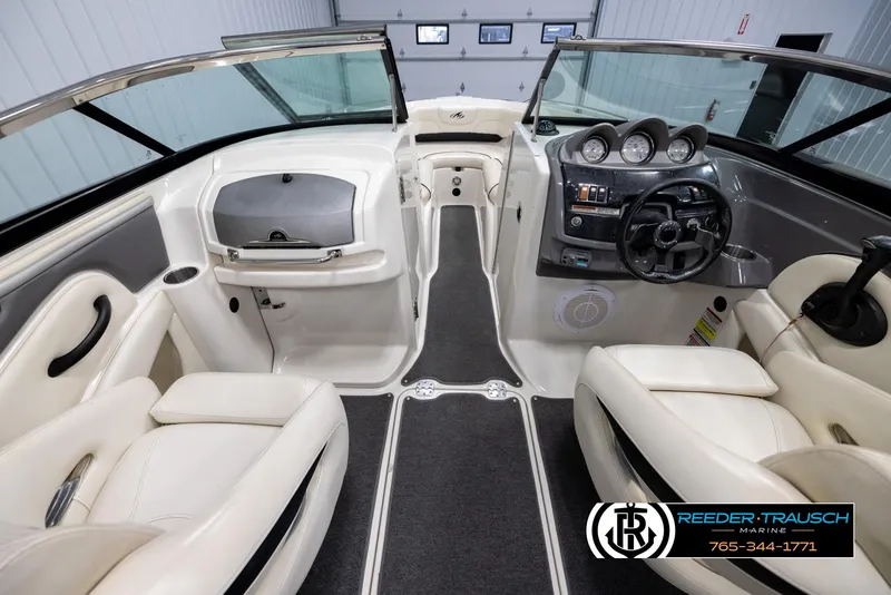 Slide: The Image of Interior of a 2007 Monterey 234 FS boat with white seating and dashboard controls. - 14