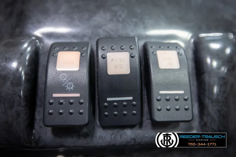 Slide: The Image of Three black control switches on a 2007 Monterey 234 FS boat dashboard. - 37