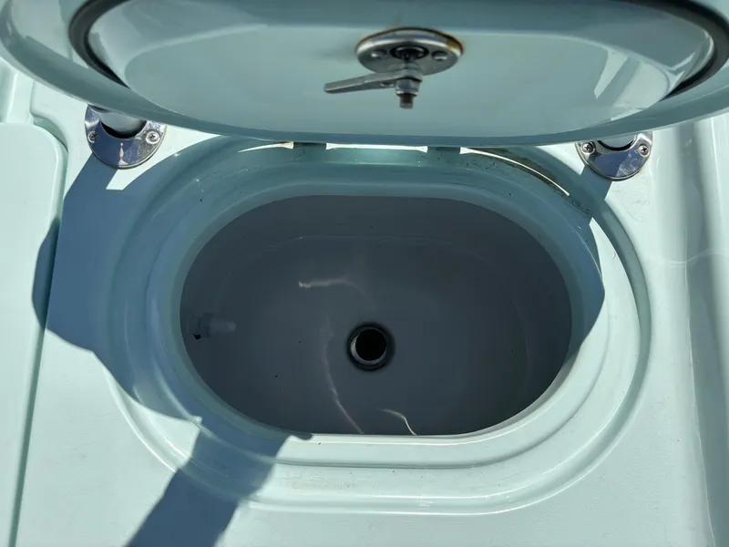 Slide: The Image of Livewell compartment on a 2024 Clark Sound 24 boat, featuring a secure lid and drain. - 12