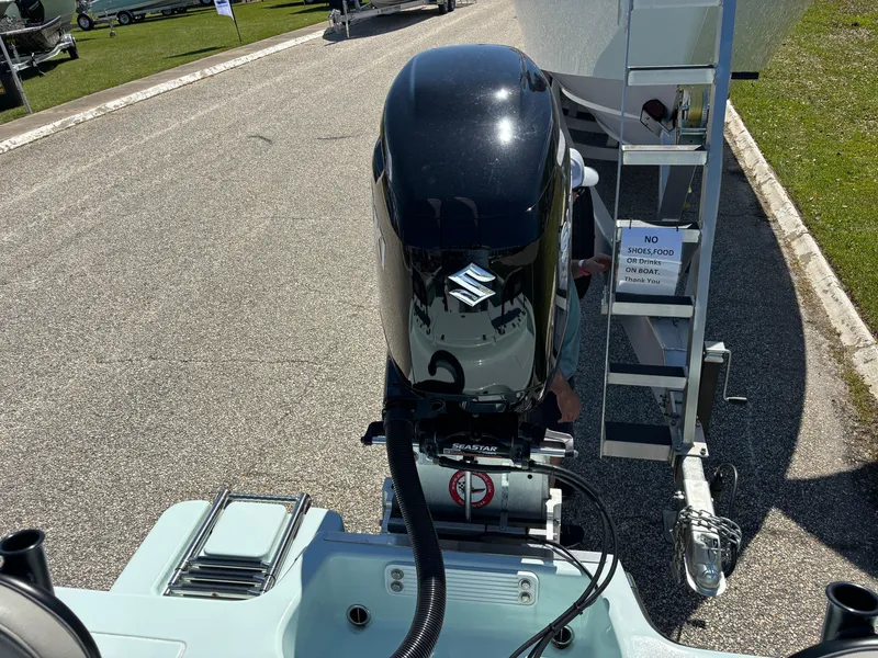 Slide: The Image of Clark Sound 24 boat with Suzuki outboard motor, parked on a sunny day, 2024 model. - 16