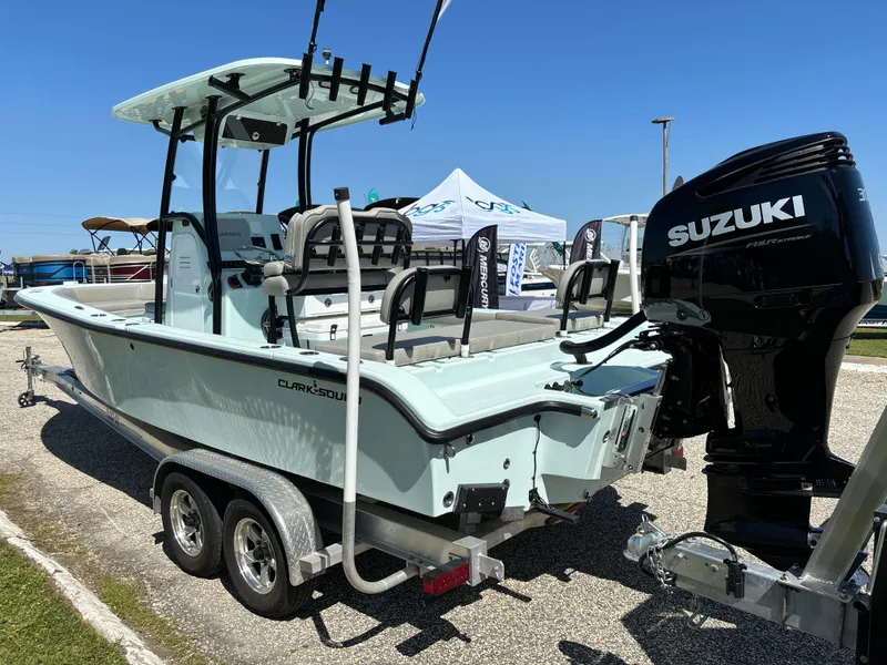 Slide: The Image of 2024 Clark Sound 24 boat with Suzuki engine on a trailer, displayed outdoors. - 3