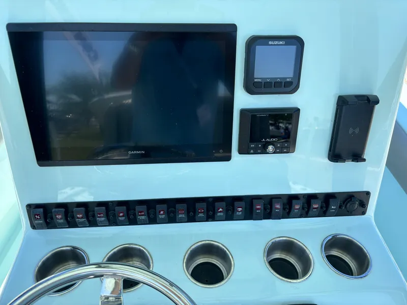 Slide: The Image of Control panel of 2024 Clark Sound 24 boat with screens and switches. - 32