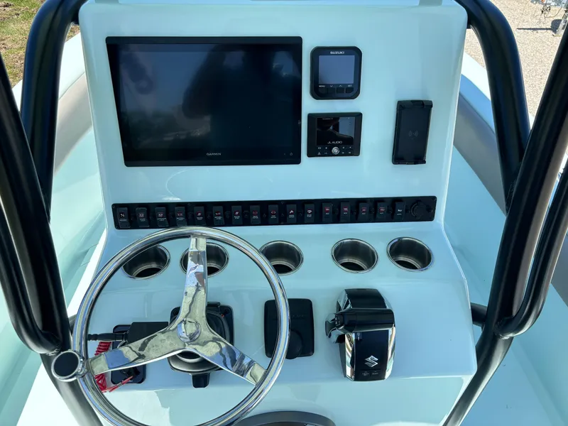 Slide: The Image of 2024 Clark Sound 24 boat dashboard with steering wheel, controls, and electronic displays. - 33