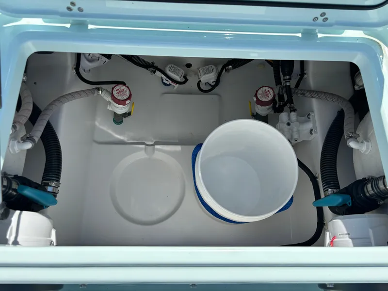 Slide: The Image of Interior view of Clark Sound 24 boat's storage compartment, featuring hoses and a bucket, 2024 model. - 9