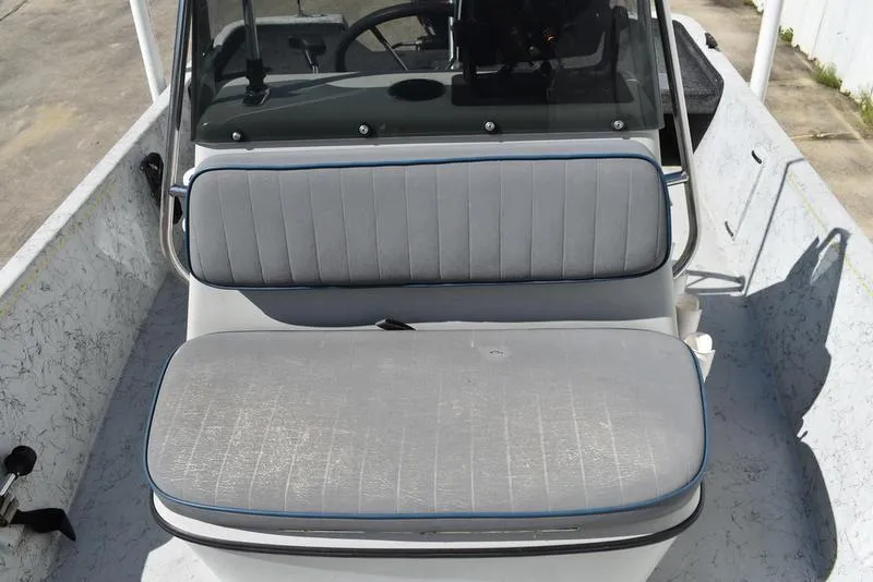 Slide: The Image of 1996 Kenner 16v boat interior with gray cushioned seating and steering console. - 14