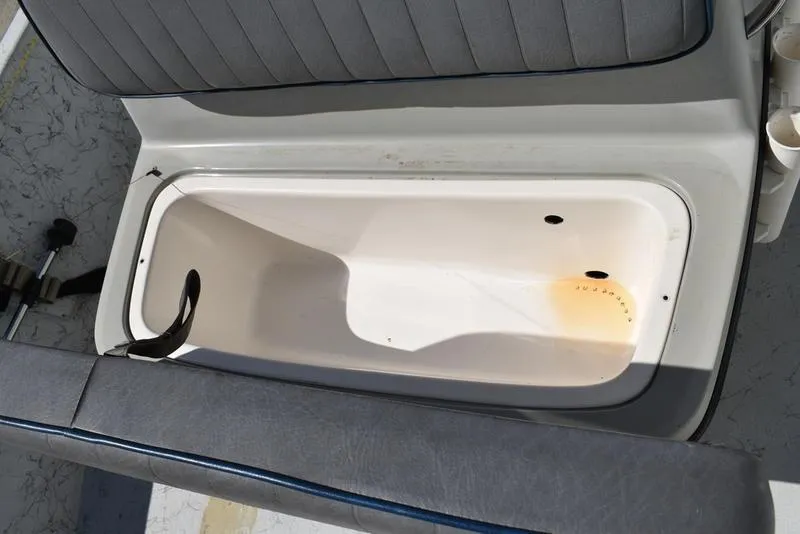 Slide: The Image of 1996 Kenner 16v boat storage compartment with gray cushioned seating. - 15