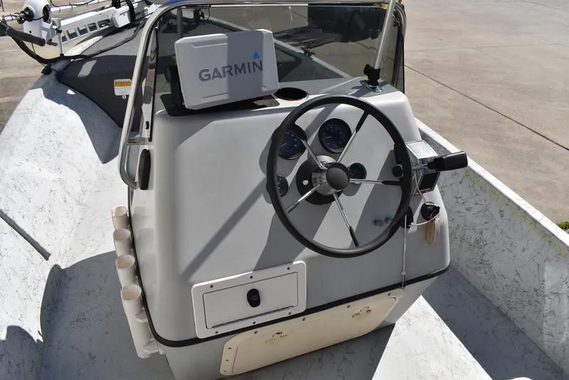 Slide: The Image of 1996 Kenner 16v boat console with Garmin GPS, steering wheel, and gauges. - 18