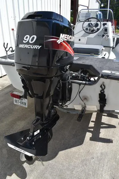 Slide: The Image of 1996 Kenner 16v boat with a 90 Mercury outboard motor, docked outdoors. - 6