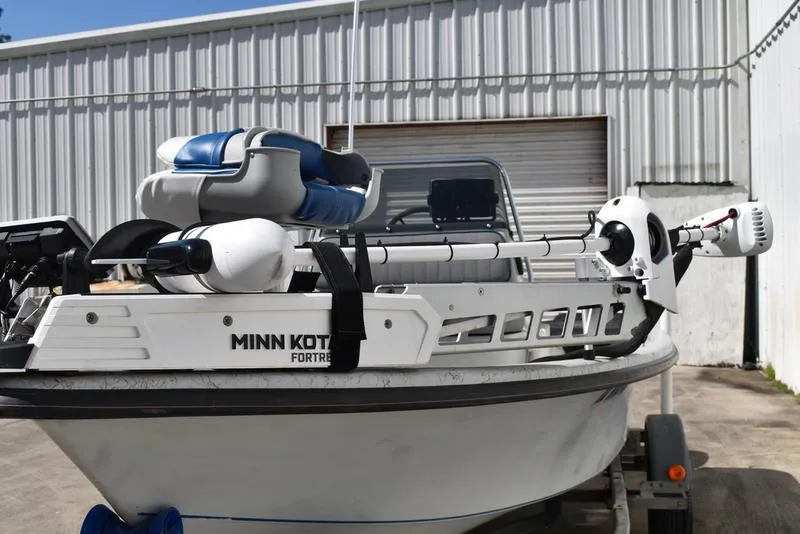 Slide: The Image of 1996 Kenner 16v boat with Minn Kota trolling motor, parked outside a metal building. - 7