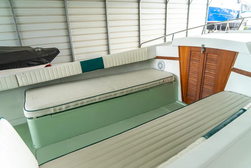 Slide: The Image of 1976 Aquasport 24 Launch boat interior with cushioned seating and wooden storage compartment. - 21