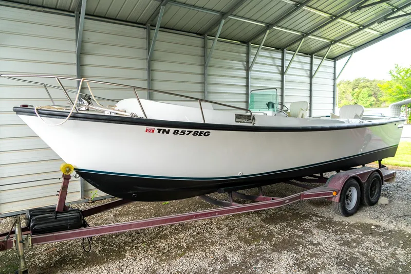 Slide: The Image of 1976 Aquasport 24 Launch boat on trailer under metal shelter. - 4