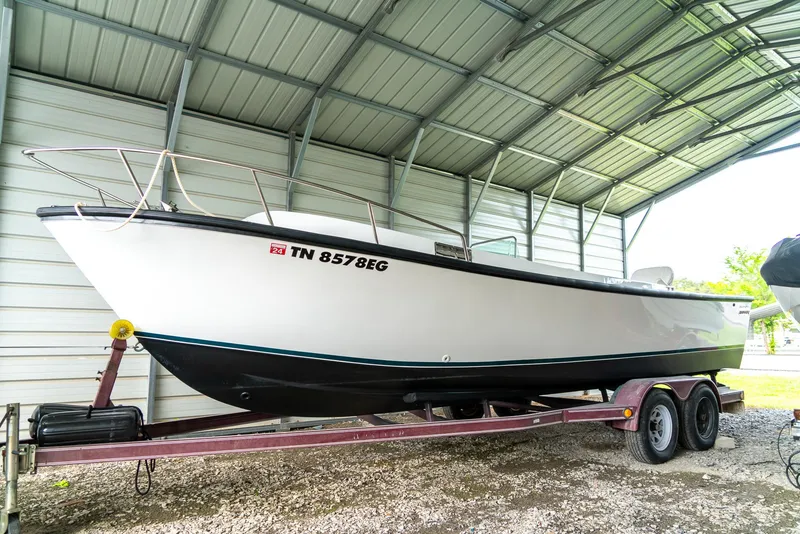 Slide: The Image of 1976 Aquasport 24 Launch boat on trailer in covered storage. - 5