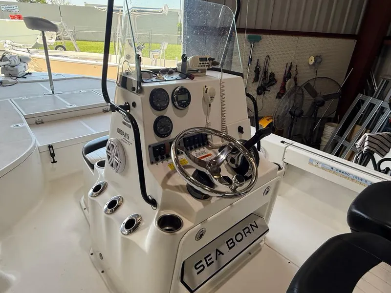 Slide: The Image of 2015 Sea Born FX22 boat console with steering wheel and gauges in a garage setting. - 11