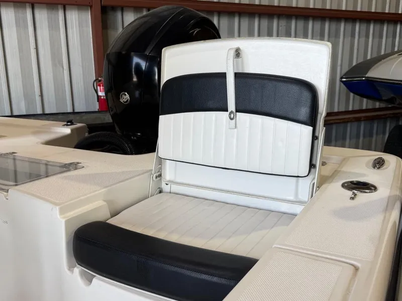 Slide: The Image of 2015 Sea Born FX22 boat seat with black and white upholstery in a storage area. - 13