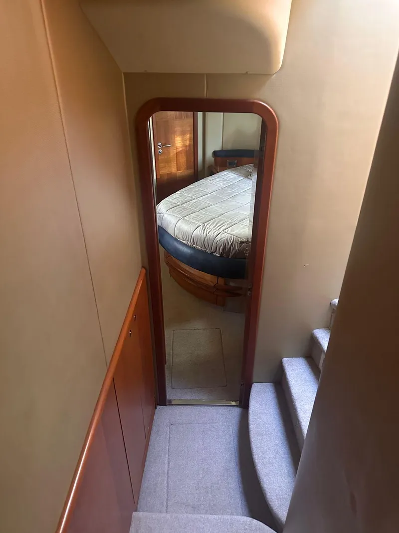 Slide: The Image of Interior view of 2007 Azimut 55E yacht, featuring a cozy bedroom and staircase. - 11