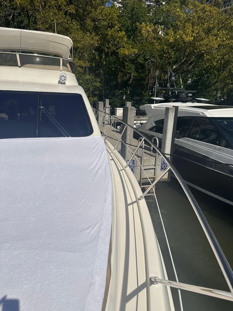 Slide: The Image of 2007 Azimut 55E yacht docked, featuring sleek design and spacious deck. - 14