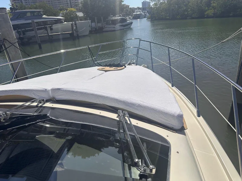 Slide: The Image of 2007 Azimut 55E yacht bow view, docked in a serene marina setting. - 15