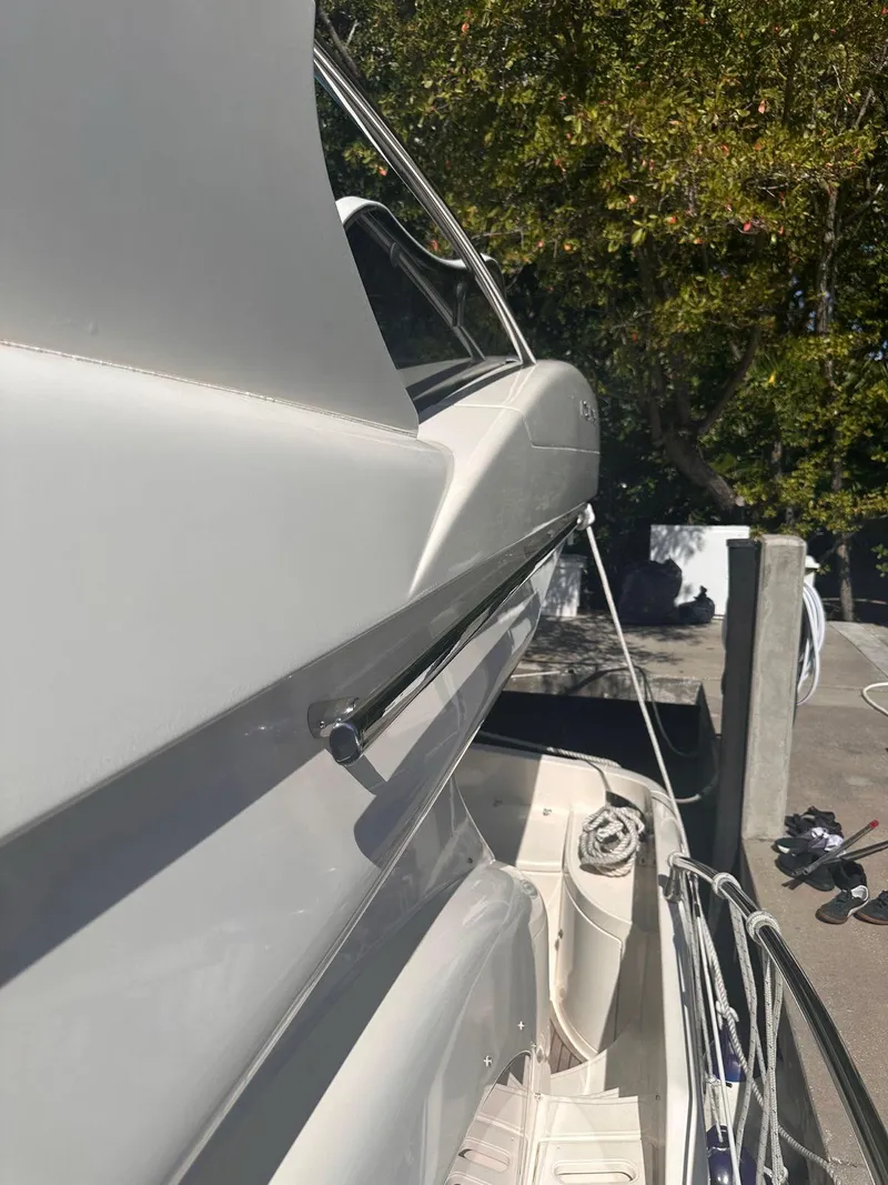 Slide: The Image of 2007 Azimut 55E yacht docked, side view with sleek design and outdoor setting. - 16