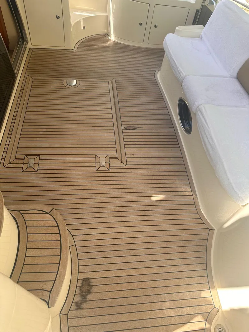 Slide: The Image of 2007 Azimut 55E yacht deck with teak flooring and white seating. - 18