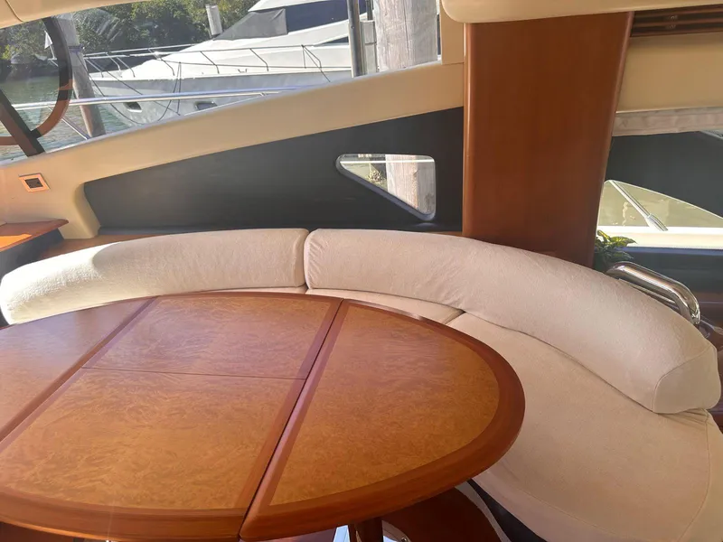 Slide: The Image of Luxurious interior of 2007 Azimut 55E yacht with elegant wood table and curved seating. - 20