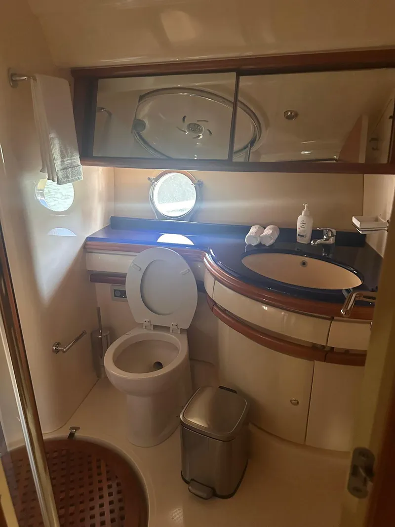 Slide: The Image of 2007 Azimut 55E yacht bathroom with toilet, sink, mirror, and porthole window. - 7