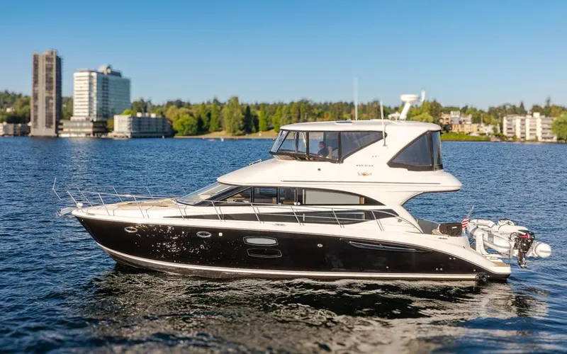 Slide: The Image of 2015 Meridian 441 Sedan yacht on a sunny day, with cityscape and trees in the background. - 3
