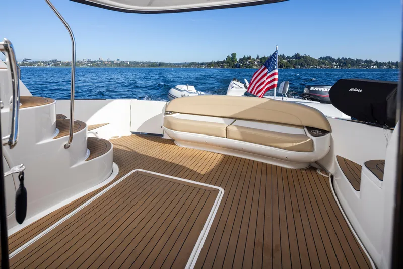 Slide: The Image of 2015 Meridian 441 Sedan yacht deck with seating, wooden flooring, and scenic water view. - 36