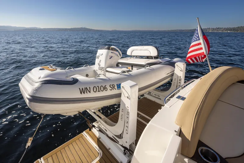 Slide: The Image of 2015 Meridian 441 Sedan with dinghy and American flag on calm water. - 38