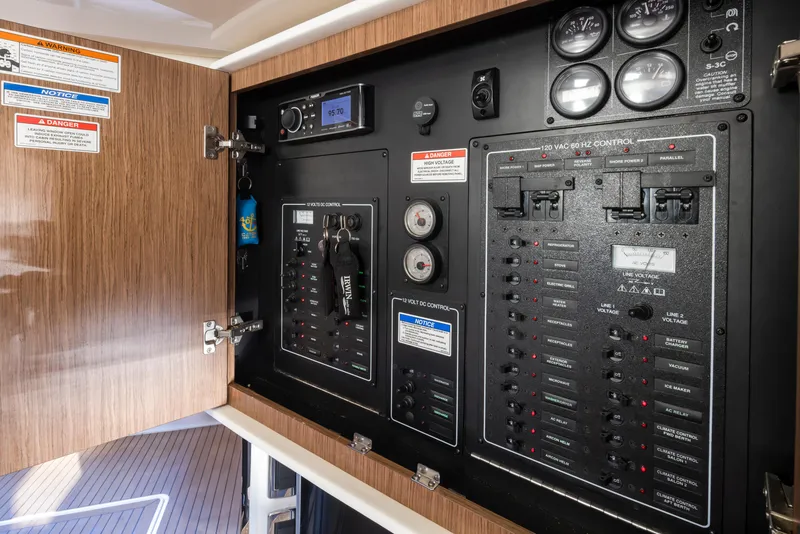 Slide: The Image of Electrical control panel inside 2015 Meridian 441 Sedan yacht, featuring switches and gauges. - 41