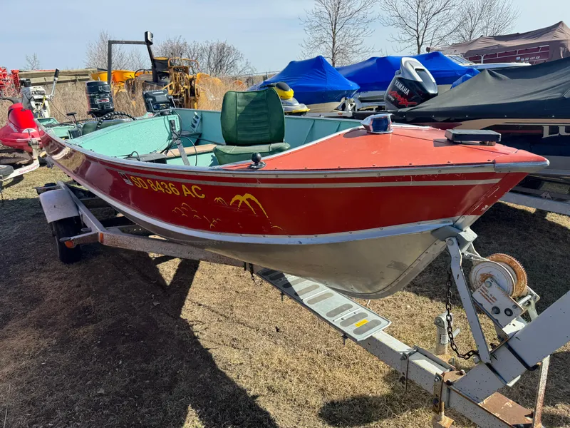 Slide: The Image of 1979 Lund L boat in red on trailer, parked outdoors with other boats. - 0