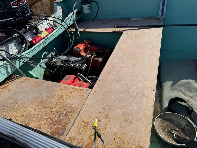 Slide: The Image of 1979 Lund L boat interior with motor, cables, and wooden flooring. - 4