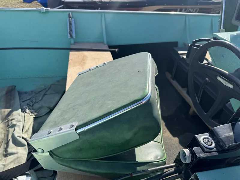 Slide: The Image of 1979 Lund L boat interior with green seat and steering wheel. - 7