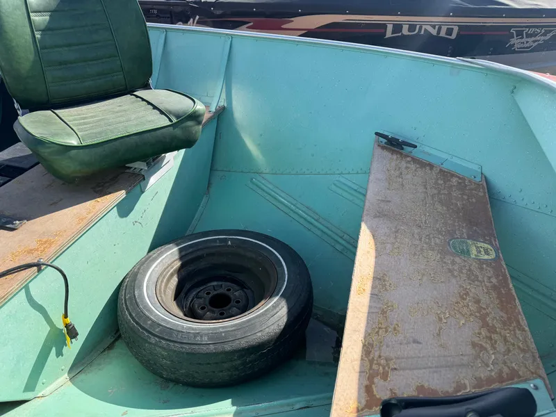Slide: The Image of 1979 Lund L boat interior with green seat and spare tire. - 9