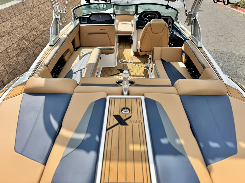 Slide: The Image of 2022 MasterCraft XStar boat interior with tan and blue seating, showcasing luxury design. - 10