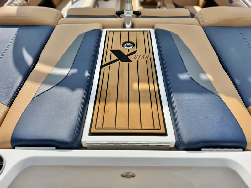 Slide: The Image of 2022 MasterCraft XStar boat interior with stylish seating and wood paneling. - 11
