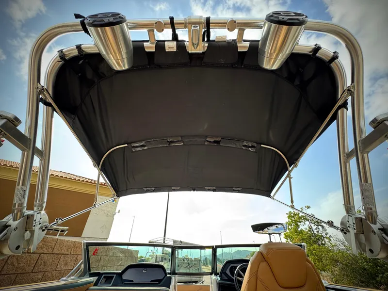 Slide: The Image of 2022 MasterCraft XStar boat with a black bimini top and stainless steel supports. - 13