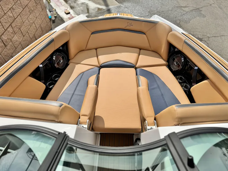Slide: The Image of 2022 MasterCraft XStar boat interior with tan and blue seating, premium audio system. - 16