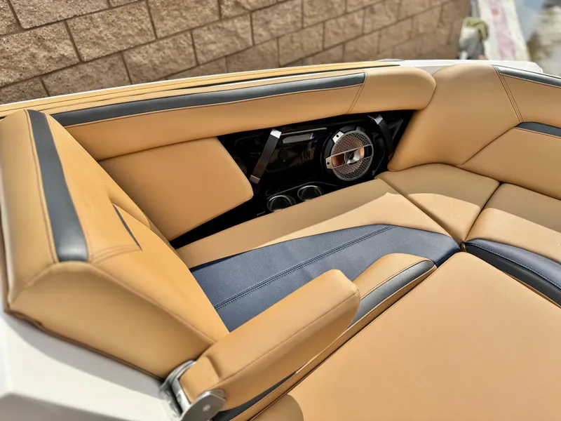 Slide: The Image of 2022 MasterCraft XStar boat interior with tan and blue upholstery, featuring a built-in speaker. - 17